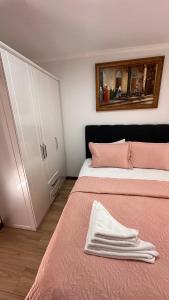 锡诺普YELKEN PANSİYON Sinop的一间卧室配有两张带粉色床单和橱柜的床。