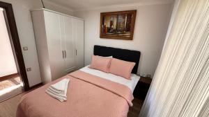 锡诺普YELKEN PANSİYON Sinop的卧室配有粉红色的床和粉红色枕头