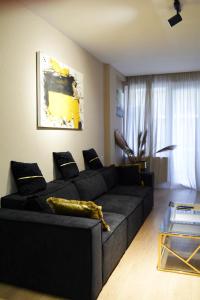 第比利斯Paliashvili 90 - VAKE Park 2BR Apartment的客厅配有黑色沙发和桌子
