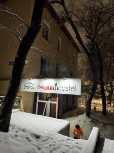 阿拉木图Лучший хостел Алматы - Масанчи的站在建筑物前的雪中的人
