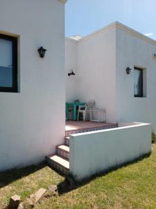 坦迪尔Hospedaje Sierra del Tigre II的白色的房子,在庭院设有桌子