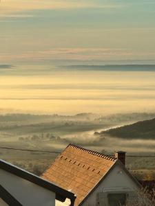 MencshelyKiskacsa Dörgicse的享有带房子的雾 ⁇ 区的景色