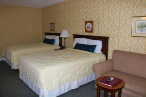 哈里森堡乡村旅馆的酒店客房,设有两张床和一张沙发
