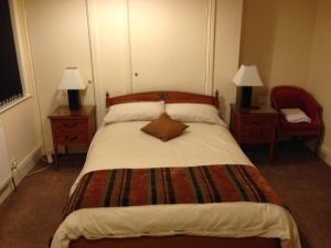 霍利韦尔维多利亚酒店的一间卧室配有一张大床、两盏灯和一把椅子