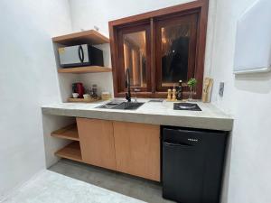 贝贝里比Jurema Dourada的厨房配有水槽和微波炉