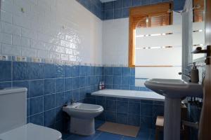 奇克拉纳－德拉弗龙特拉Namawa Surfhouse的蓝色瓷砖浴室设有卫生间和水槽