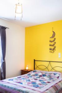 SkouloúfiaRural Residence的一间卧室设有一张床和黄色的墙壁