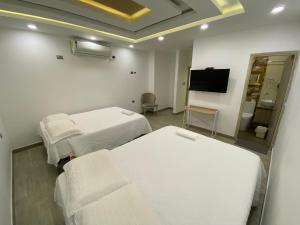 CurumaníHotel Dubai Deluxe Curumani的一间医院间 - 带两张床和一台平面电视