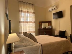 切法卢Sicilian Dream Apartments的一间卧室配有一张带灯和镜子的床