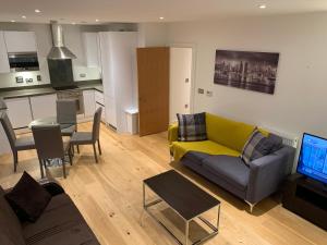 伦敦Dockland Excel 2 Bedroom Apartment的一间带黄色沙发的客厅和一间厨房