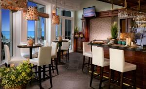 劳德代尔堡鹈鹕海滩度假度假酒店 - 贵族之家 的餐厅内的酒吧设有白色的椅子和窗户