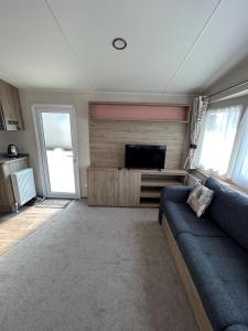 纽基Beautiful Caravan With Decking At Trevella Holiday Park, Newquay, Ref 98082hs的带沙发和平面电视的客厅