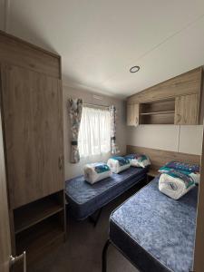 纽基Beautiful Caravan With Decking At Trevella Holiday Park, Newquay, Ref 98082hs的小房间设有两张床和窗户