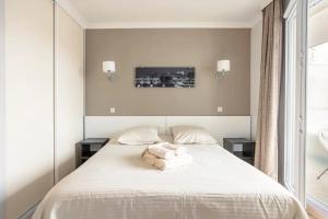 库尔布瓦Appartement lumineux au calme的卧室配有白色的床和2个枕头