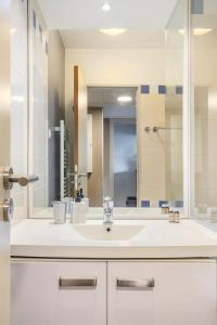库尔布瓦Appartement lumineux au calme的一间带水槽和大镜子的浴室