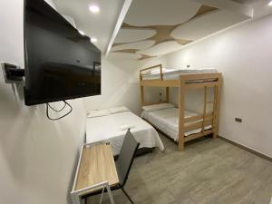 CurumaníHotel Dubai Deluxe Curumani的小房间设有一张床和一台平面电视