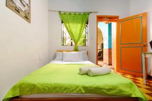 卡利Ding-Dong Hostel的一间卧室配有绿床和2条毛巾
