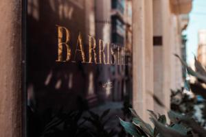 瓦莱塔The Barrister Hotel的有一个商店的窗口,上面有理发店的名字