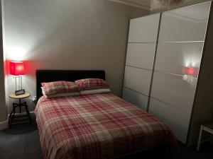 卡诺斯蒂The Old Post Office Double Room (town centre)的一间卧室配有一张带拼接棉被的床