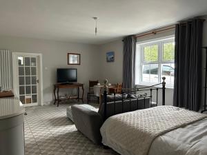 CaistorCaistor Bed & Breakfast的一间卧室配有一张床,客厅配有电视
