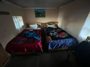 奥科苏尤MOON NIGHT Amantani Lodge的两张睡床彼此相邻,位于一个房间里