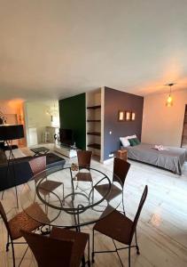 卡特勒博尔纳Cosy suite in the heart of Ebene的一间设有玻璃桌、椅子和一张床的房间