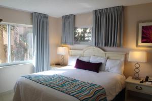 帕诺滩Canada House Beach Club Resort的一间卧室设有一张大床和两个窗户。