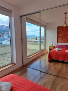 乌斯怀亚Lo de Moli 5A的一间卧室设有红色的床和大窗户