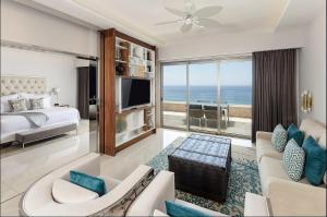 卡波圣卢卡斯Residential Retreat 1 Bedroom Suite Garza Blanca Resort & Spa的一间带一张床的客厅和一间带电视的客厅