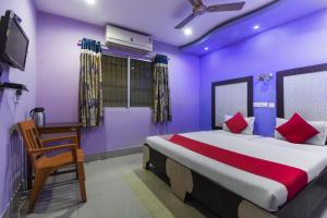 杜尔加布尔Hotel Kohinoor的一间卧室设有一张紫色墙壁的大床
