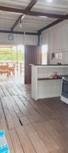 阿居鲁特乌亚Casa de Praia - Ajuruteua Pará的厨房铺有木地板,配有白色橱柜。