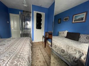圣伦纳兹Livadia House at St Leonards on Sea的一间卧室设有一张床和蓝色的墙壁