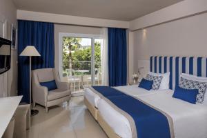甘达坞伊港Iberostar Selection Diar El Andalous的卧室配有床、椅子和窗户。