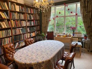 圣伦纳兹Livadia House at St Leonards on Sea的一个带桌椅的图书馆和一个大窗户