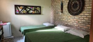 马拉卡贾Pousada Parracho的一间设有两张床和砖墙的房间