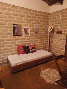 卡瓦坎特Casa Jasmim的砖墙前的一间配有沙发的房间