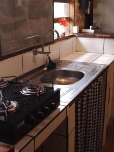 卡瓦坎特Casa Jasmim的厨房柜台设有水槽和炉灶。