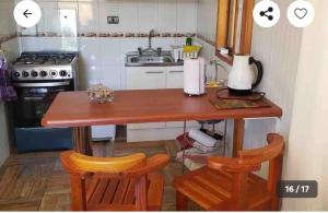 奥索尔诺Cabañas ruta internacional 215 I, Osorno的厨房配有木桌和两把椅子