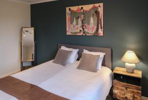 布鲁日兰花旅馆的卧室配有两张床,墙上挂着一幅画