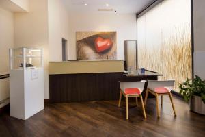 热那亚贝斯特韦斯特PLUS城市酒店的一间设有两把椅子的等候室,配有心画