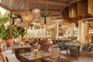 马斯喀特The St Regis Al Mouj Muscat Resort的餐厅设有桌椅和吊灯。