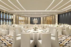 马斯喀特The St Regis Al Mouj Muscat Resort的一间会议室,配有桌子和白色椅子