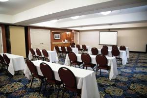 弗雷斯诺弗雷斯诺希尔顿恒庭旅馆&套房酒店的一间会议室,配有桌椅和屏幕