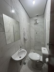 阿帕雷西达Pousada Recanto Da Fé的白色的浴室设有卫生间和水槽。