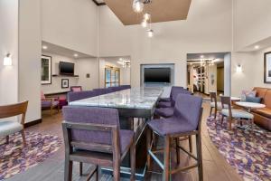 弗林特弗林特格朗德布兰科汉普顿套房旅馆的大堂设有带紫色椅子的大型酒吧