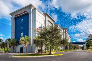 塔马拉克费劳德代尔/西索格拉斯/塔马拉克（佛罗里达州）希尔顿恒庭旅馆&套房酒店的一座挂着美国国旗的酒店大楼