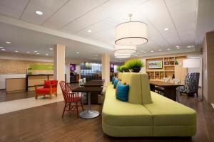 格林斯伯勒Home2 Suites by Hilton Greensboro Airport, NC的大堂配有沙发和桌椅