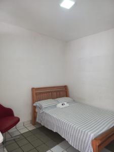 累西腓Excelentes Quartos com banheiros privativos的一间小卧室,配有一张床和一把红色椅子