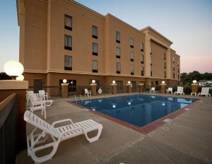Yazoo City亚祖城汉普顿酒店的一座带游泳池和椅子的酒店和一座建筑