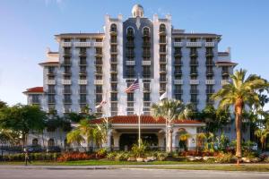 劳德代尔堡Embassy Suites by Hilton Fort Lauderdale 17th Street的一座棕榈树环绕的大建筑